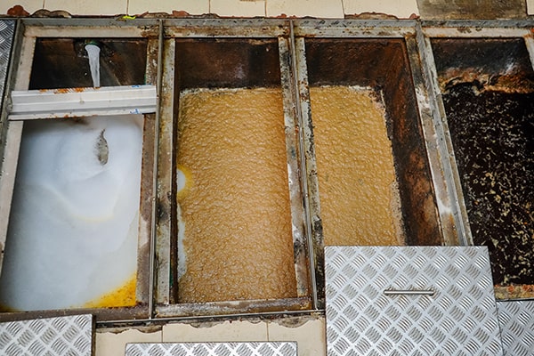 foul odors, slow draining sinks, and visible grease buildup are all indicators that grease trap maintenance is needed